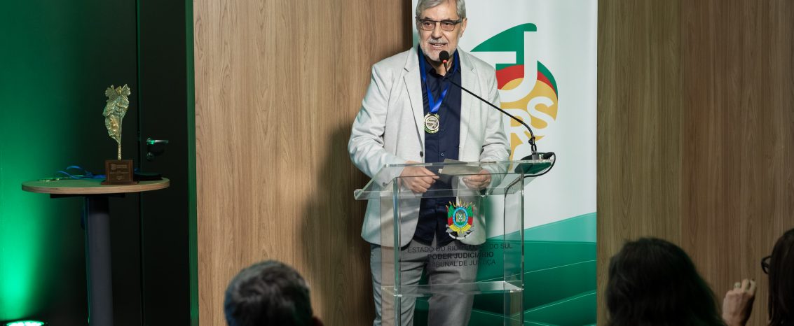 Diretor-geral Paulo Gilvane Borges, no palco, agradecendo a medalha Alberto André, concedida pela ARI