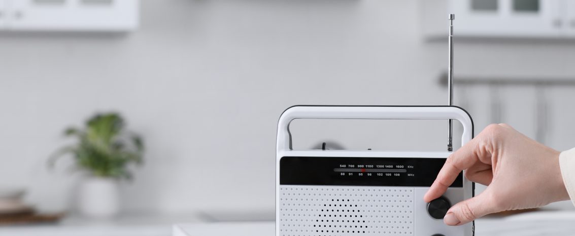 Mão de uma mulher ligando o rádio.